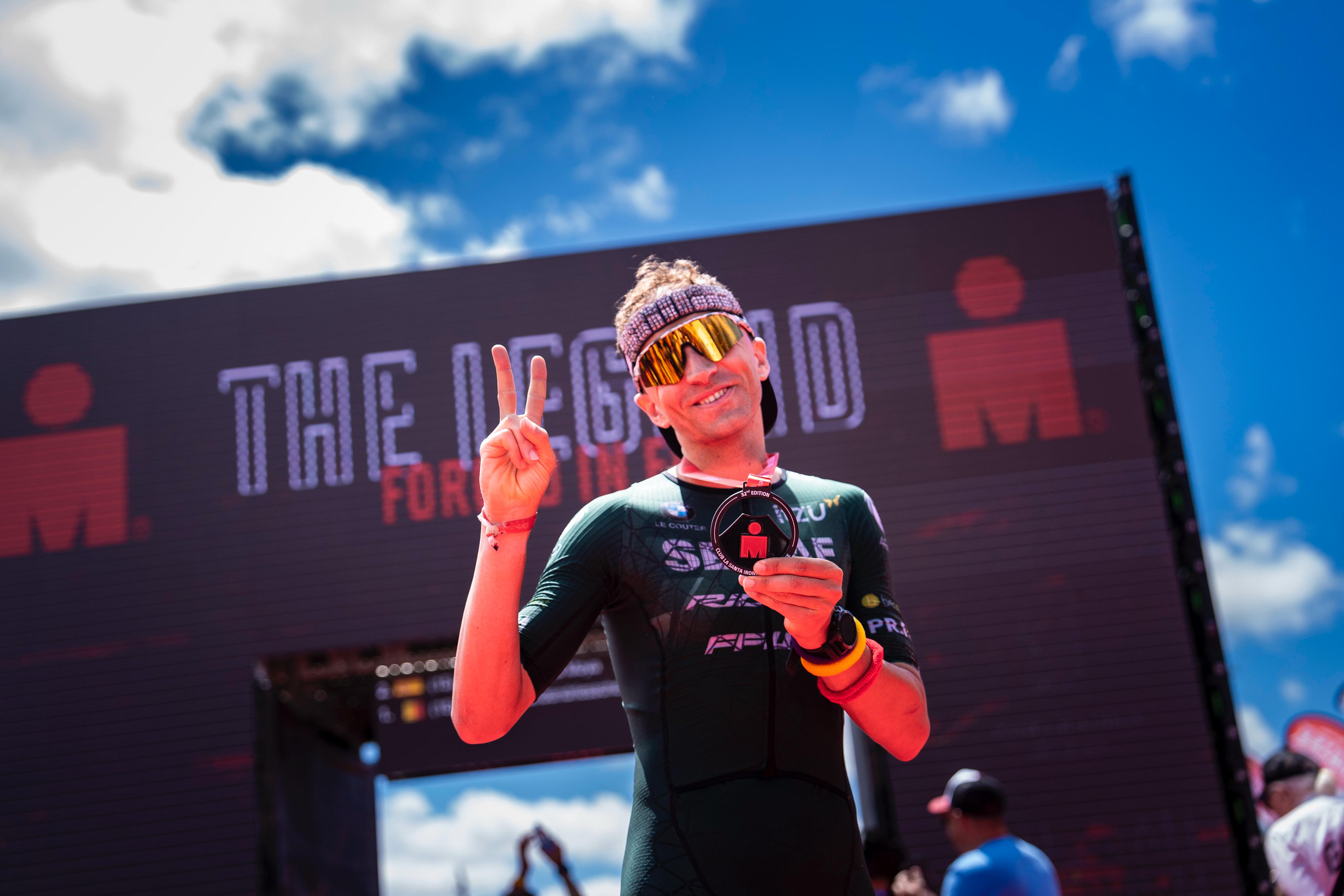 Kenneth Vandendriessche holding his Ironman medal